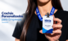 Mulher segurando crachá personalizado em PVC com cordão azul da Ideia Gráfica & Brindes para identificação de funcionários em empresas.